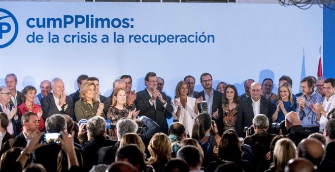 Rajoy (c), rodeado por los miembros de su Gobierno, recibe los aplausos de los asistentes al acto 'CumPPlimos: De la crisis a la recuperación', en el que ha hecho hoy balance de su gestión, tras una semana convulsa para los populares, marcada por la crisi