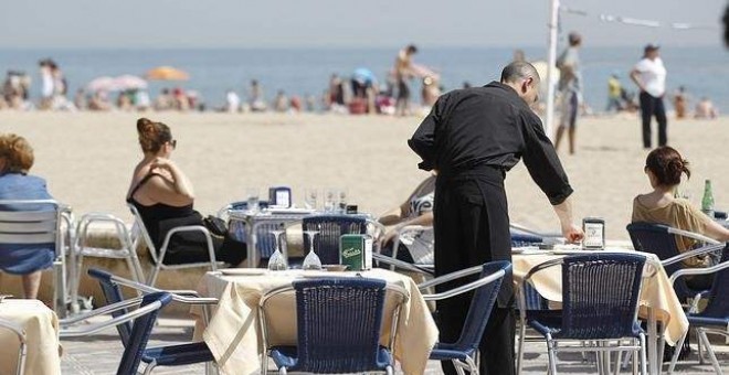 Un camarero atiende a una pareja en una terraza este verano. /EFE