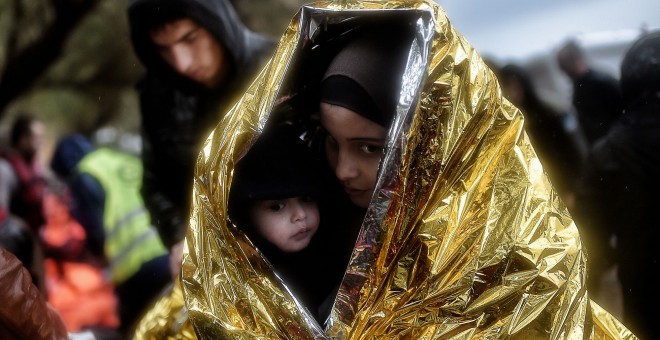 Los niños intentan entrar en calor con mantas de emergencia mientras llegan otros refugiados e inmigrantes a la isla griega de Lesbos. AFP / ARIS MESSINIS