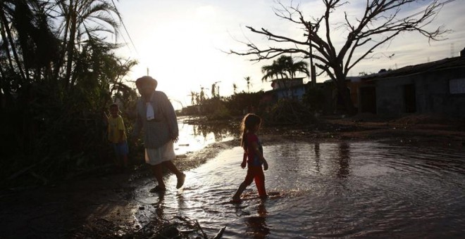 Una familia de la comunidad Emiliano Zapata recorre una calle tras el paso del huracán Patricia hoy, sábado 24 de octubre de 2015, en el municipio de la Huerta, en el estado de Jalisco (México).- EFE