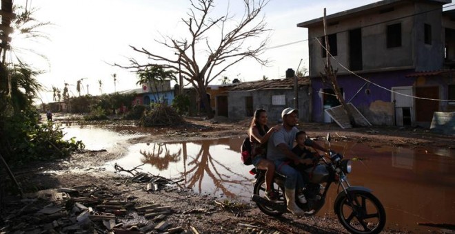 Una familia transita en una motocicleta hoy, sábado 24 de octubre de 2015, tras el paso del huracán Patricia en una calle de la comunidad de Emiliano Zapata (México)