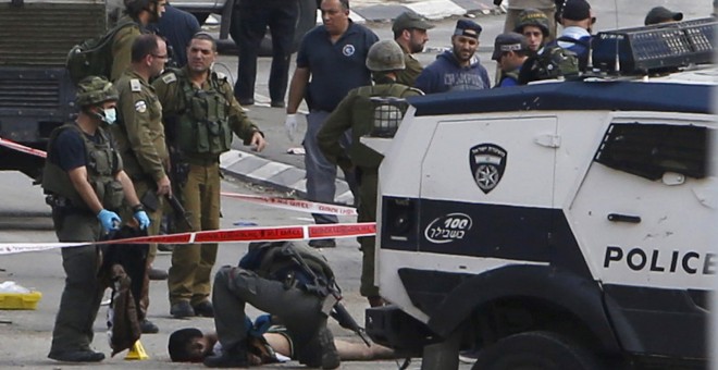 La policía israelí cachea a un joven palestino que, según Tel Aviv, habría atacado con un cuchillo en la ciudad cisjordana de Hebrón a varios soldados. REUTERS/Mussa Qawasma