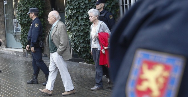 El expresidente de la Generalitat, Jordi Pujol, acompañado de su esposa, Marta Ferrusola, salen de su domicilio de la Ronda General Mitre durante el registro por parte de  agentes de la Unidad de Delincuencia Económica y Fiscal (UDEF) de la Policía Nacion