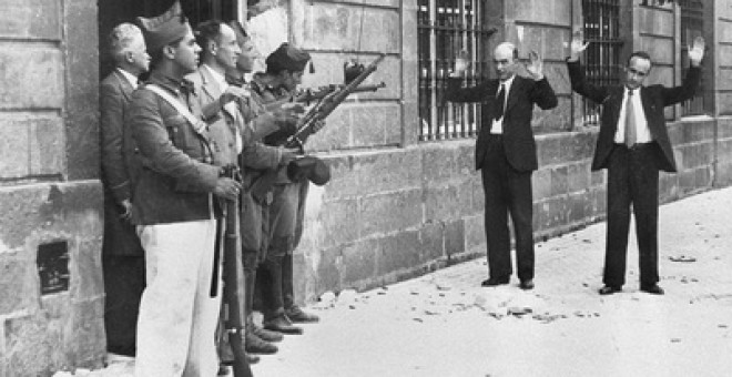 Soldados favorables a Franco encañonan a dos transeúntes, en una calle de Sevilla, al inicio de la Guerra Civil. / EFE