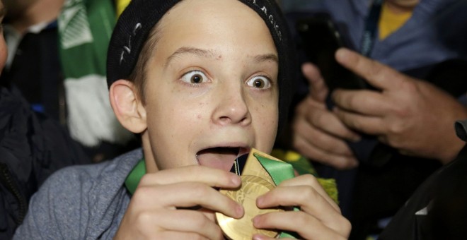 El afortunado joven que se llevó la medalla de Bill Williams. REUTERS/Henry Browne
