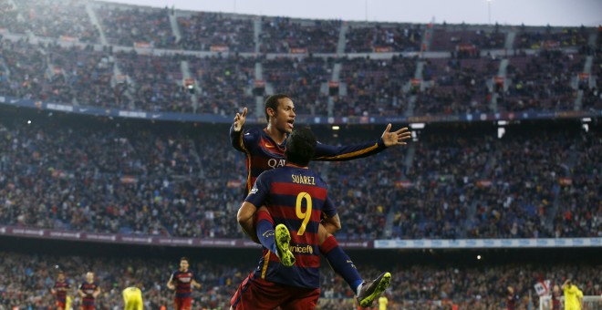El delantero uruguayo Luis Suarez levanta a su compañero Neymar, tras su segundo gol frente al Villarreal en el Camp Nou. REUTERS/Albert Gea
