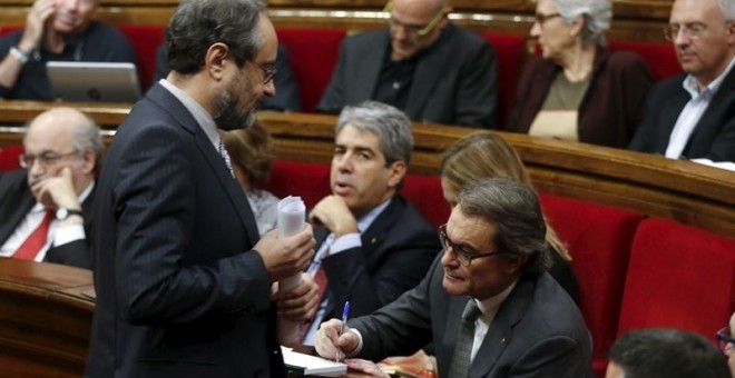 Antonio Baños pasa junto a Artur Mas ayer en la sesión en el Parlament. /EP