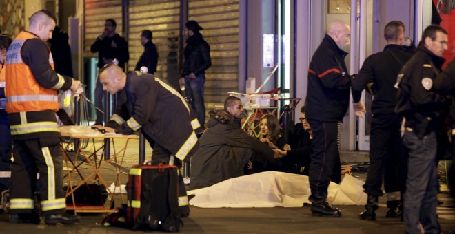 El personal de servicios de rescate trabajan cerca de los cuerpos cubiertos fuera de un restaurante después de un tiroteo en París, Francia, 13 de noviembre de 2015. REUTERS / Philippe Wojazer