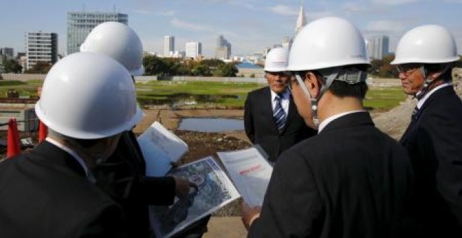varios cargos del consejo de deportes de Japón miran un mapa del lugar donde se construirá el estadio para los Juegos Olímpicos de 2020.- REUTERS
