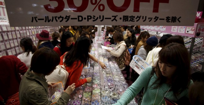 Unas compradoras buscan en un expositor de laca de uñas con descuento en Tokio. REUTERS / Yuya Shino