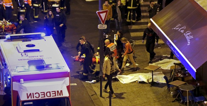 Miembros del cuerpo de bomberos parisino traslada a una ambulancia a un herido en el ataque terrorista a la sala de conciertos 'Bataclan'. REUTERS/Christian Hartmann