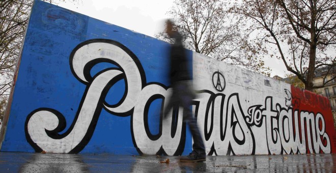 Un hombre pasa junto a un grafitti reciente que dice 'París te amo' en la Plaza de la República en París, Francia. REUTERS / Jacky Naegelen