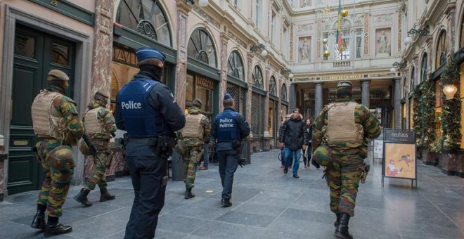 Police officer and soldiers on security duty inside Galerie de la Reine following the terror alert level being elevated to 4/4, in Brussels, Belgium, 22 November 2015. Belgium raised the alert status to maximum because of a 'serious and imminent' threat