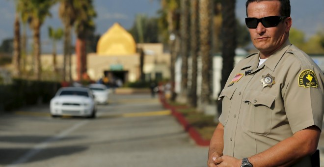 Un policía cerca de la mezquita Dar Al Uloom Al Islamiyah-Amer, en San Bernardino (California), a donde acudía uno de los sospechos del tiroteo, Syed Rizwan Farook. REUTERS/Mike Blake