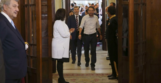 El líder de Podemos y candidato a la Presidencia del Congreso, Pablo Iglesias, y el ex JEMAD y número dos de la formación por Zaragoza, Julio Rodríguez, a su llegada a la recepción celebrada en Madrid con motivo del XXXVII aniversario de la Constitución.