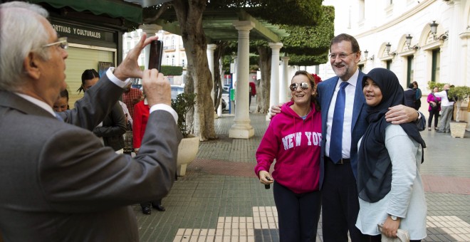 Fotografía facilitada por el PP del presidente del Gobierno y del partido, Mariano Rajoy, fotografiado con dos ciudadanas melillenses por el presidente de Melilla, Juan José Imbroda, durante la visita que ha realizado a la Ciudad Autónoma. EFE/Tarek