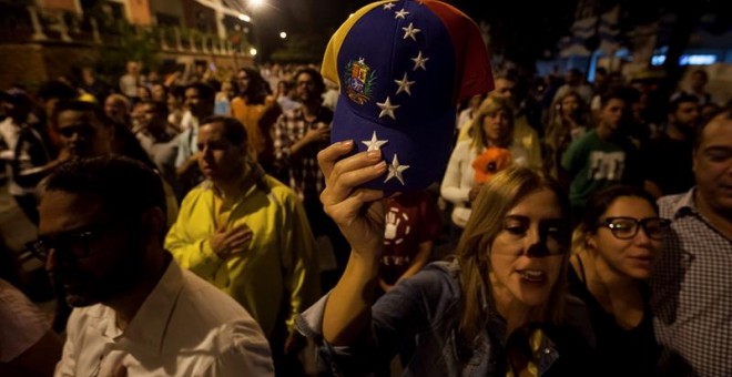 Un grupo de personas celebra la victoria obtenida por la coalición opositora Mesa de Unidad Democrática (MUD)  este lunes en Caracas./ EFE