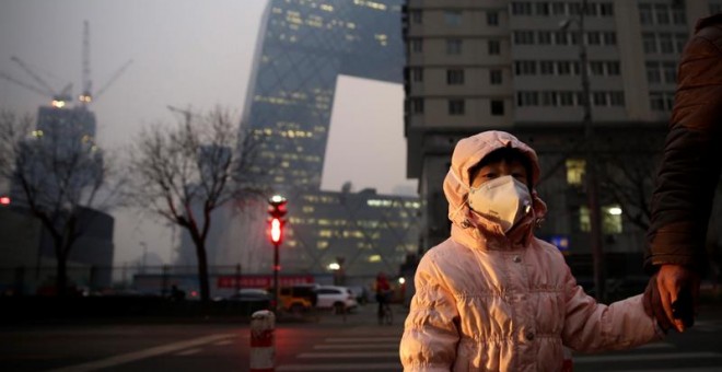 Una niña usa una mascarilla para protegerse de la contaminación ambiental en Pekín, China