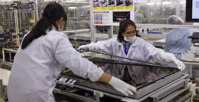 Dos mujeres ensamblan un televisor en una fábrica de Tokio. /REUTERS