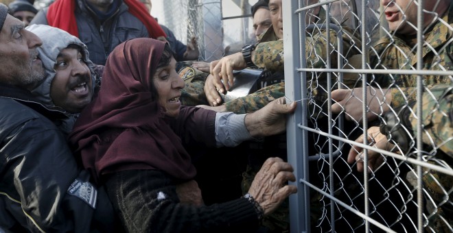 Refugiados sirios intentan pasar la frontera en Macedonia. REUTERS/Yannis Behrakis