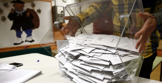 El presidente de una mesa electoral deposita los votos de la urna sobre una mesa para proceder a su recuento./EFE/Jesús Diges