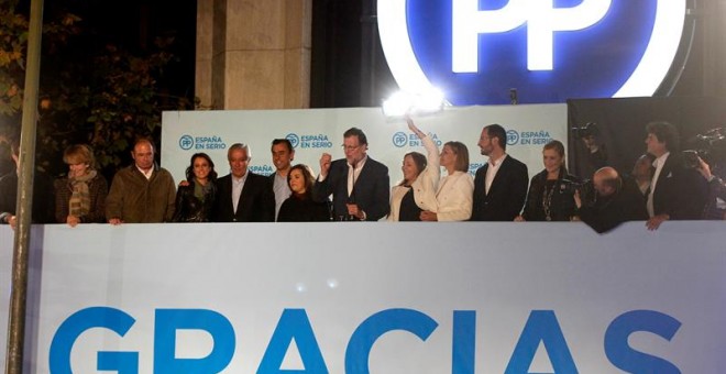 El presidente y candidato del Partido Popular a la Presidencia del Gobierno, Mariano Rajoy, acompañado de los dirigentes del PP habla a sus simpatizantes en el exterior de la sede de su partido en la calle Génova tras conocerse los resultados de las elec