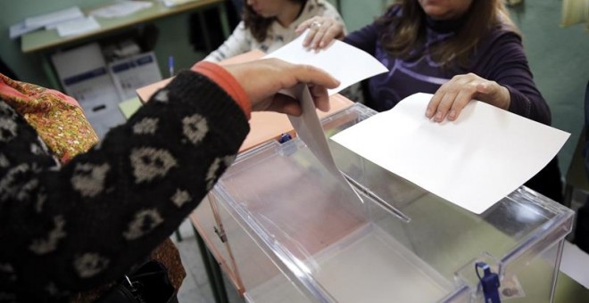 Una mujer introduce sus votos en las urnas durante el 20-D. EFE/Mariscal