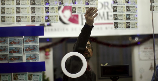 Un vendedor de lotería de la localidad malagueña de Ronda, con décimos para el sorteo de Navidad. REUTERS/Jon Nazca