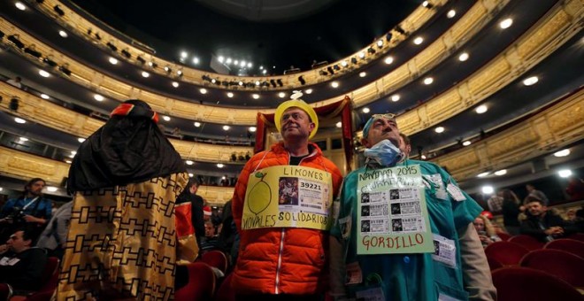 Algunas personas disfrazadas esperan en el interior del Teatro Real a que dé comienzo el Sorteo Extraordinario de Navidad. /EFE