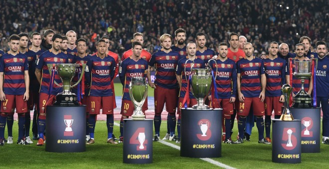 La plantilla del FC Barcelona posa con los cinco títulos conseguidos en 2015 antes del partido de Liga ant el Betis en el Nou Camp. REUTERS/Stringer