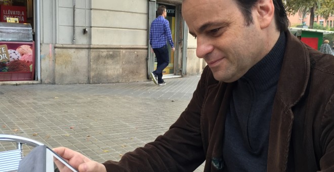 Jaume Asens consulta su iPad en un chaflán de Barcelona.