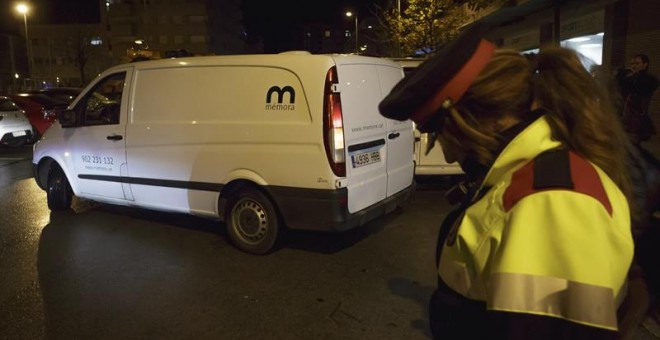 Un vehículo traslada el cadáver del niño hallado por los mossos en un piso de Giron. / DAVID BORRAT (EFE)