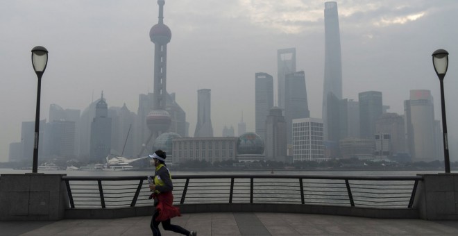 Un hombre con mascarilla hace ejercicio cerca del distrito financiero de Shangai. REUTERS
