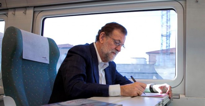 Fotografía facilitada por el PP del presidente del Partido Popular y presidente en funciones del Gobierno, Mariano Rajoy, tomando notas en el tren en el que viaja hacia Zamora,donde participa en un acto del Partido Popular./ EFE