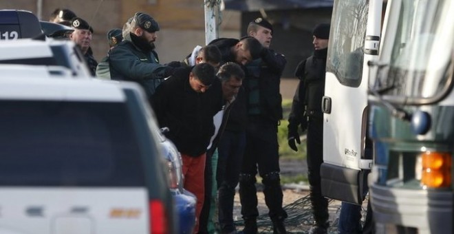 Agentes de la Guardia Civil detienen a unos hombres sospechosos de estar involucrados en el robo de cable de cobre durante una redada en el asentamiento de chabolas de El Gallinero. REUTERS