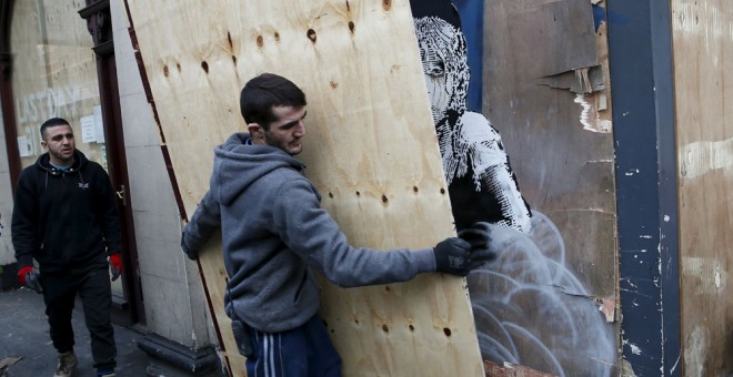 Un trabajador cubre la obra de Banksy en Londres. REUTERS