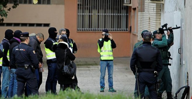 Agentes de las Fuerzas y Cuerpos de Seguridad del Estado durante el registro efectuado en la sede de la peña Indar Gorri de Osasuna.- EFE