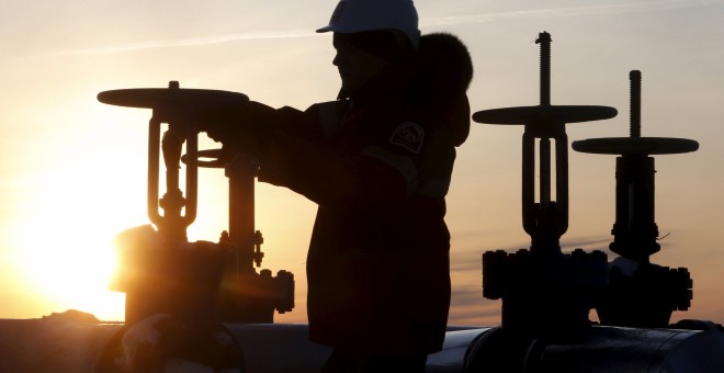 Un trabajador maneja la válvula de un conducto de petróelo en un campo petrolífero de la compañía rusa Lukoil en Sberia. REUTERS/Sergei Karpukhin