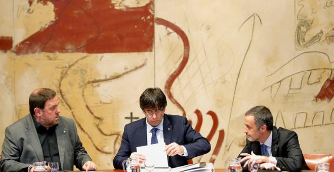 El presidente de la Generalitat, Carles Puigdemont, conversa con el vicepresidente, Oriol Junqueras y el secretario del Govern, Joan Vidal. EFE