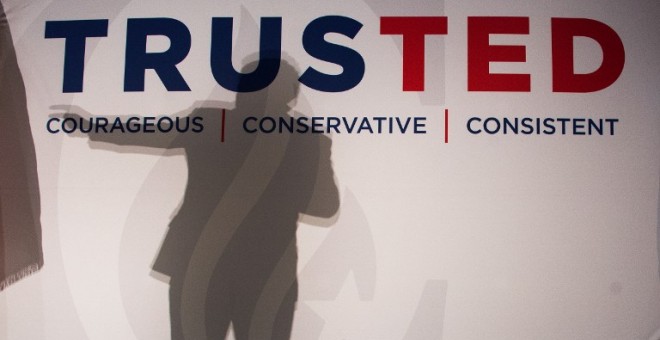 La silueta de Ted Cruz se refleja en una pancarta de su candidatura. - AFP