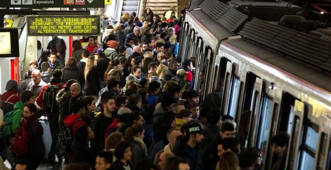 Usuarios del Metro de Barcelona esperan en el andén de la estación de Plaza España la llegada de un convoy. / QUIQUE GARCÍA (EFE)