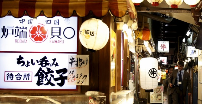 Un viandante pasa junto a unos bares típicos japoneses en el barrio comercial de Tokio. REUTERS/Yuya Shino