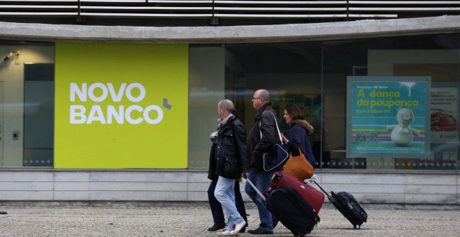 Varias personas pasan por delante de una sucursal de Novo Banco. REUTERS