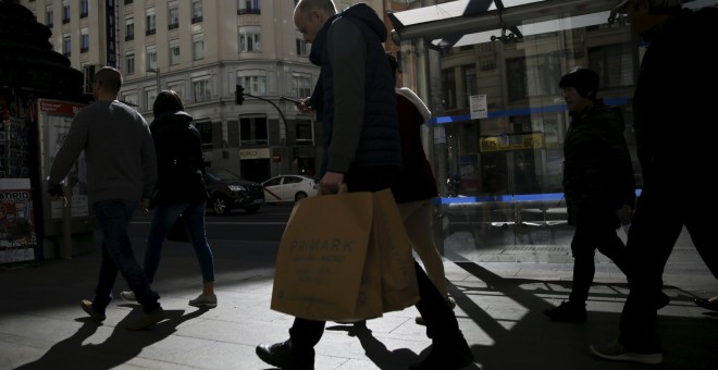 Varias personas con las bolsas de sus compras por el centro de Madrid. REUTERS/Andrea Comas