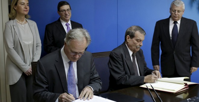 Christian Leffler (i), el principal negociador europeo para las conversaciones entre la UE y Cuba, y el vicecanciller Abelardo Moreno (d) firman un acuerdo para normalizar las relaciones en el Ministerio de Asuntos Exteriores en La Habana. REUTERS / Enriq