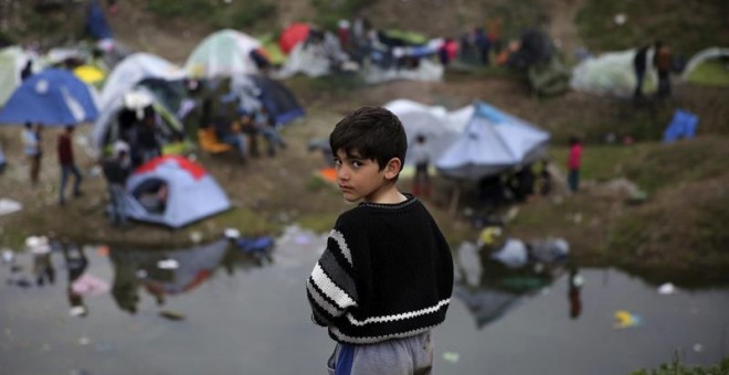 Un niño sirio permanece en el campamento provisional de refugiados en Idomeni, Grecia. EFE/Orestis Panagiotou