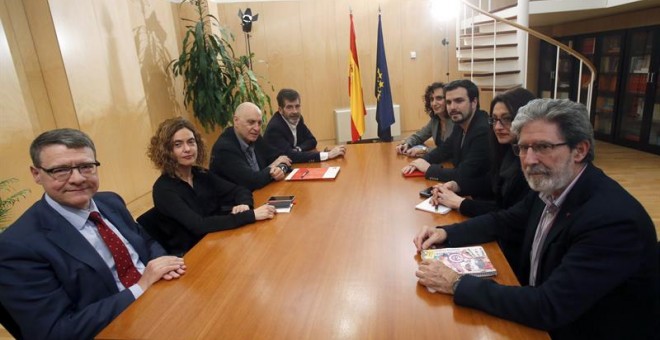 Los miembros de la comisión negociadora del PSOE Jordi Sevilla (i), Meritxell Batet (2i), Rodolfo Ares (3i) y José Enrique Serrano (4i), y de IU, Adoldo Barrena (d), Sol Sánchez (2d), Alberto Garzón (3d), e Isabel Elbal (4d), durante la reunión que ambos