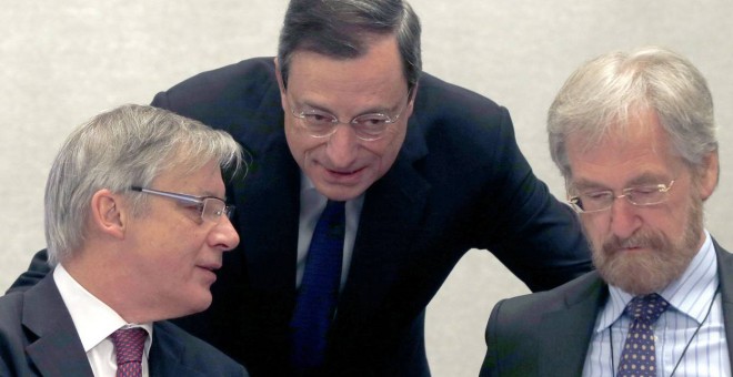 El presidente del BCE, Mario Draghi, conversa con el economista jefe de la entidad Peter Praet, en presencia del esgobrnador del Banco de Francia. REUTERS
