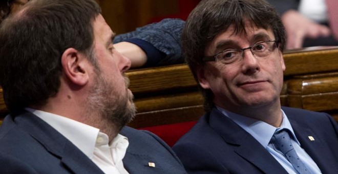 El presidente de la Generalitat, Carles Puigdemont, y su vicepresidente, Oriol Junqueras, durante la sesión de control al gobierno catalán que se celebra en el Parlament de Cataluña, un día después de la reunión del lider del PSOE, Pedro Sánchez, con el p