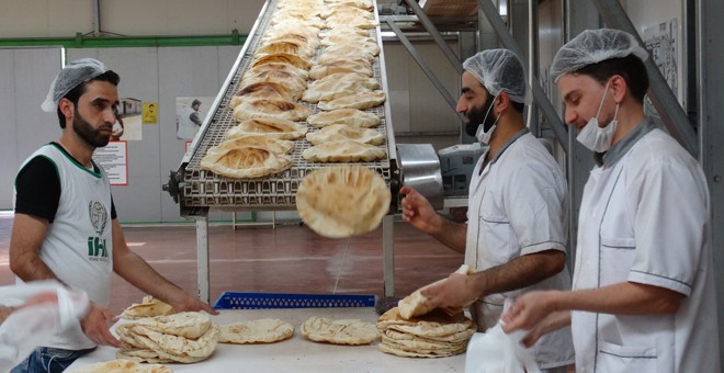 La Fundación de Ayuda Humanitaria (IHH) hornea 120.000 panes al día en la frontera turco-siria. / CORINA TULBURE